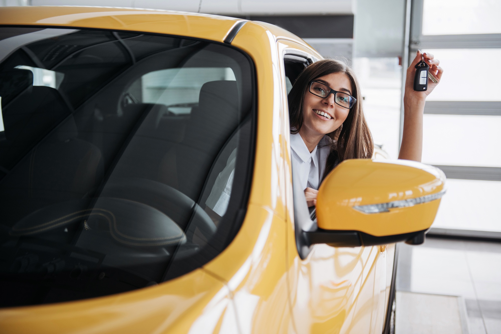 The woman driver smiling showing new car keys